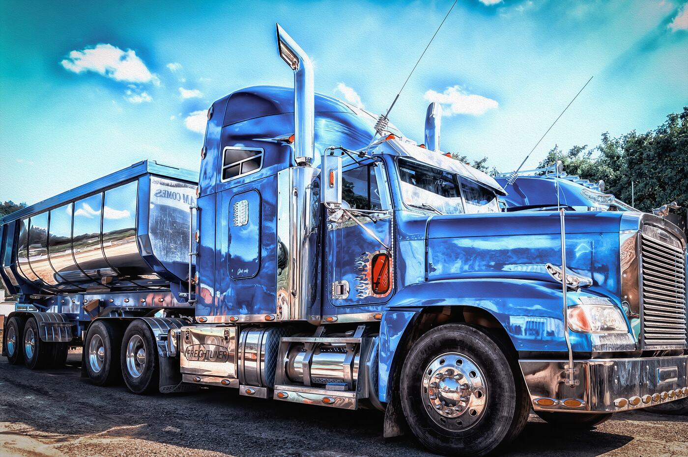 A blue semi truck with a tanker trailer