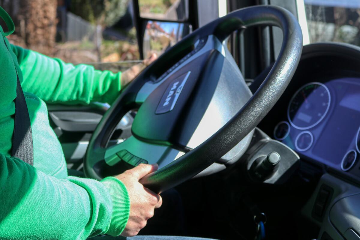 A driver's hands on the steering wheel of a truck
